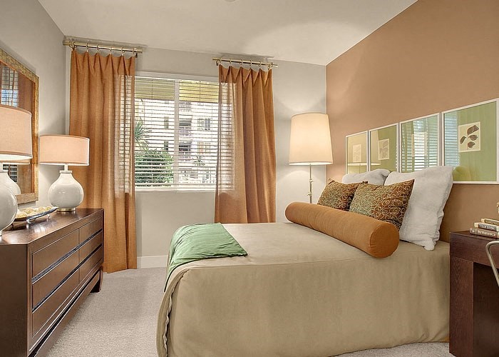 a bedroom with a large bed next to a window