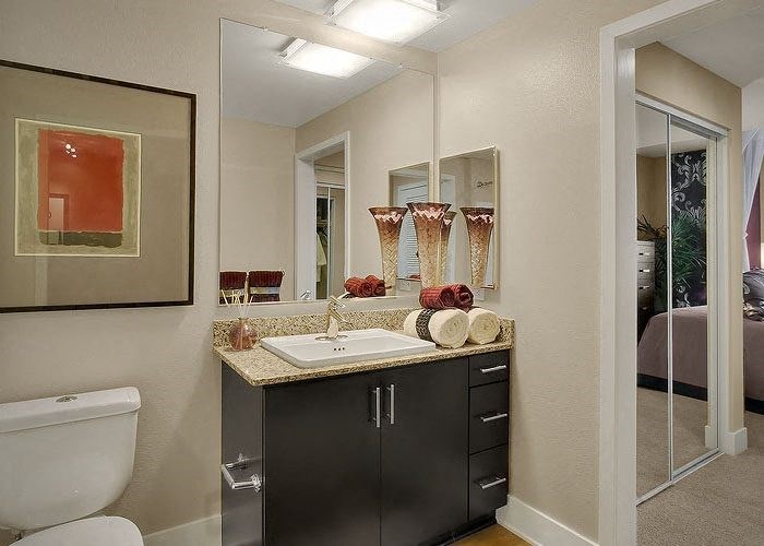 a bathroom with a toilet sink and mirror