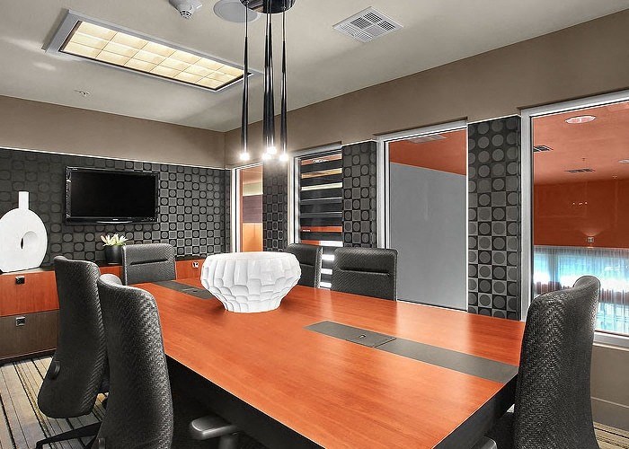 a conference room with a wooden table and black chairs
