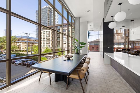 A modern dining room with a long table and chairs.