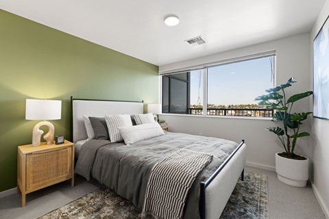 A bedroom with a large bed and a view of the outside.
