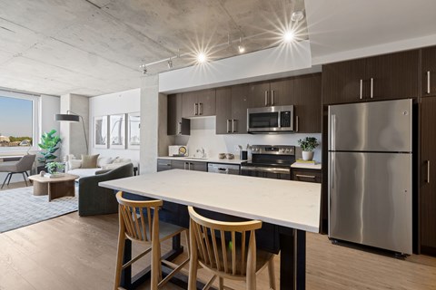 A modern kitchen with a bar area and a view of the city.