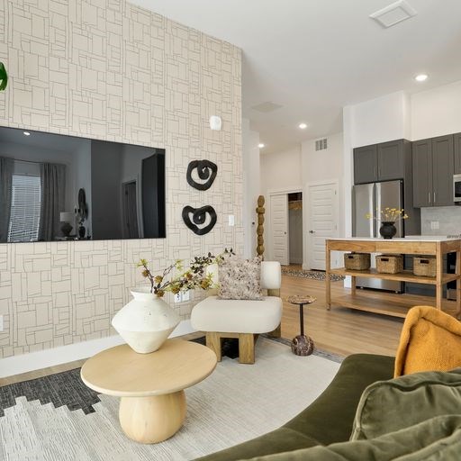 A living room with a white chair, a wooden table, and a green blanket.