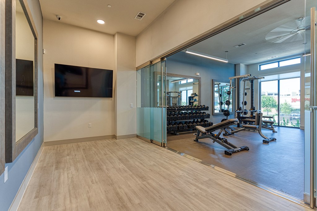 a gym with a tv and exercise equipment