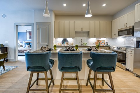 A kitchen with a bar area and two chairs.