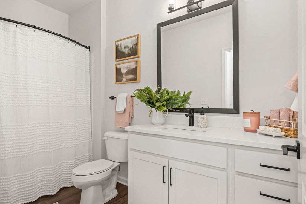 a white bathroom with a large mirror and a toilet