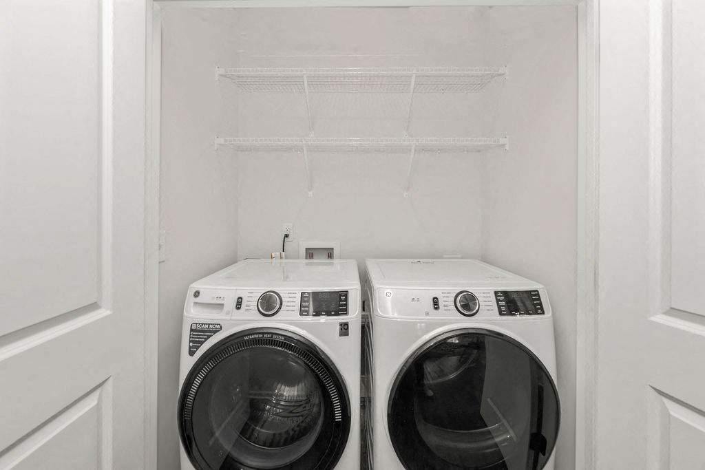 a white washer and dryer in a white closet