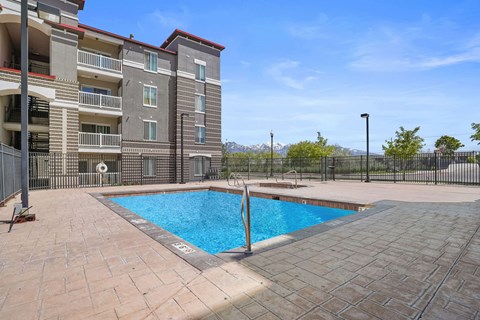 A swimming pool in a residential area surrounded by a black fence.