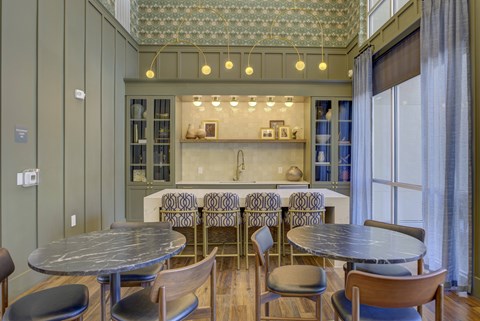 A dining room with a table surrounded by chairs.