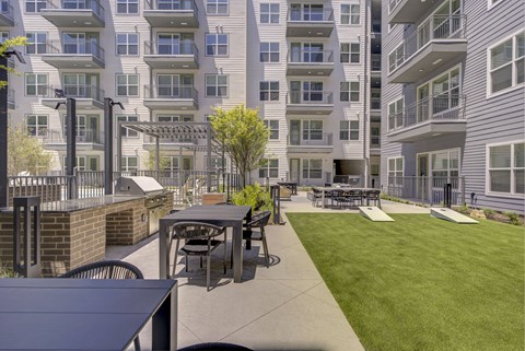 A patio with a table and chairs is surrounded by apartment buildings.