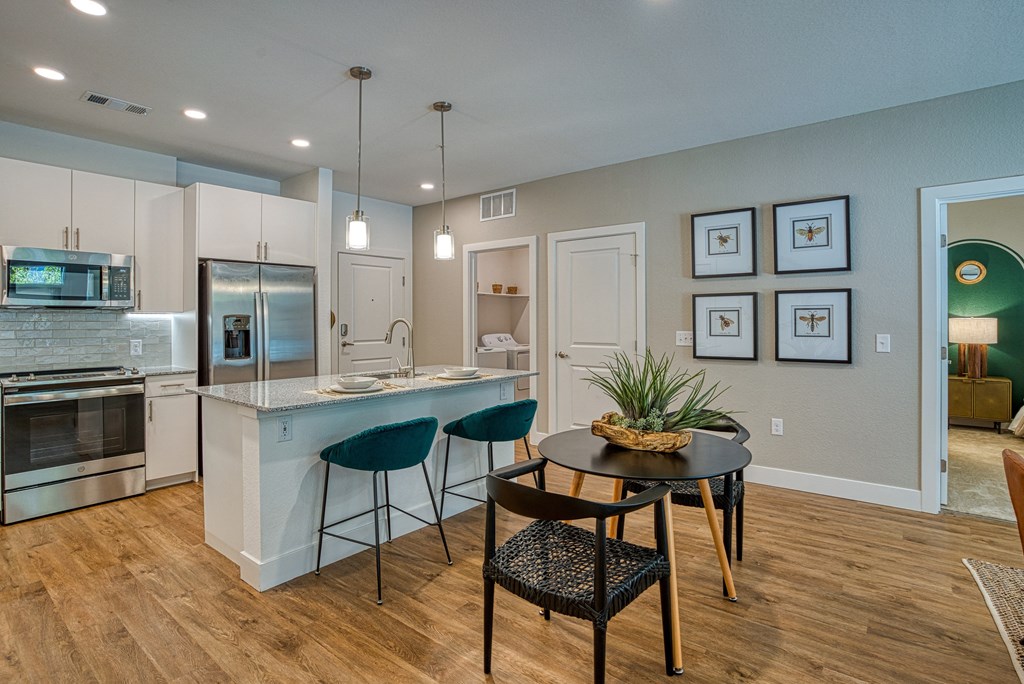 a kitchen with an island and a table with chairs