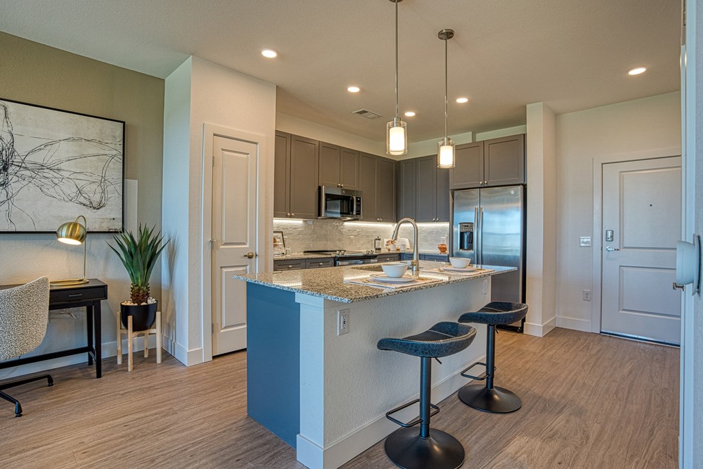 an open kitchen with a large island with stools