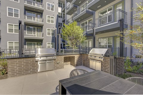A modern apartment complex with a courtyard and a tree.