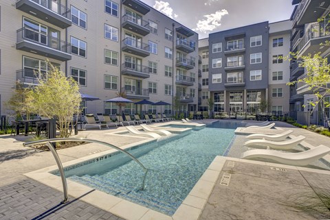 A swimming pool in front of apartment buildings.