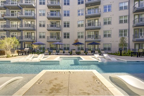 A large swimming pool in front of apartment buildings.