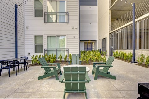 A patio with green chairs and a table.