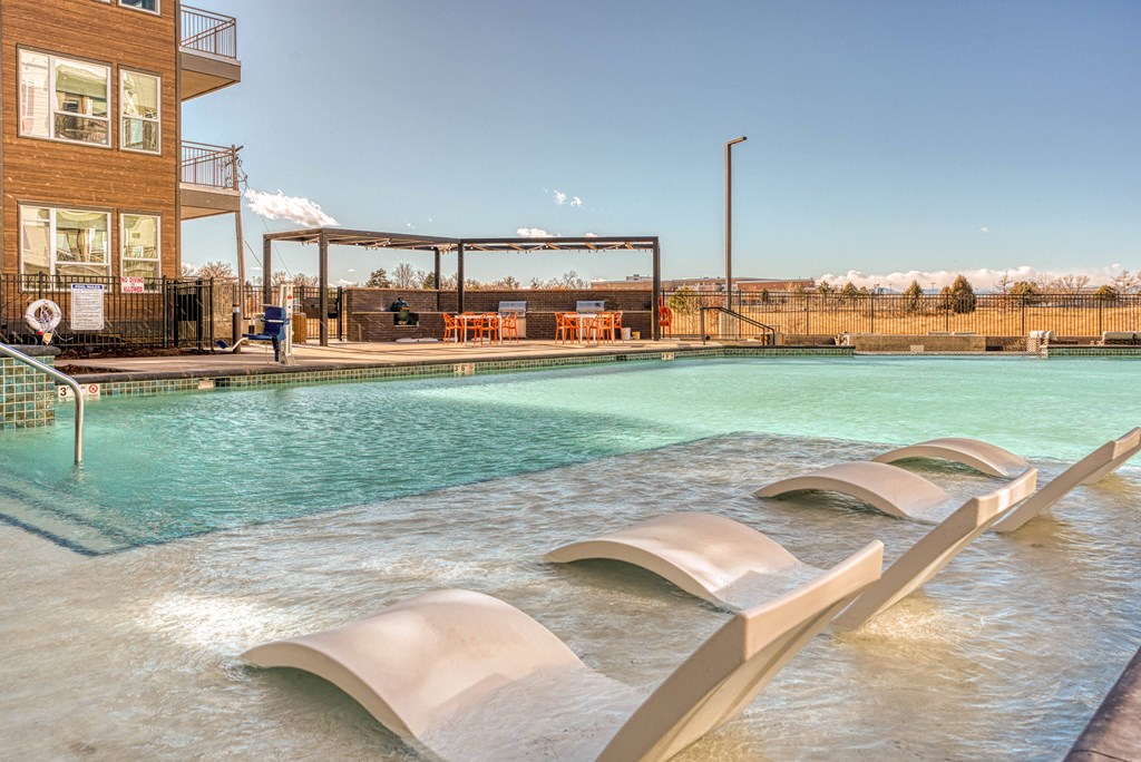 Swimming pool with sun shelf and lounge chairs