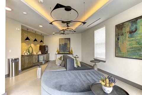 A modern living room with a grey sofa and a large abstract painting on the wall.