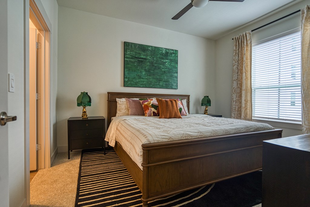 a bedroom with a bed and a painting on the wall