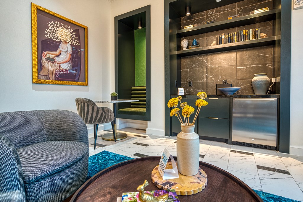 a living room with a blue chair and a table with yellow flowers