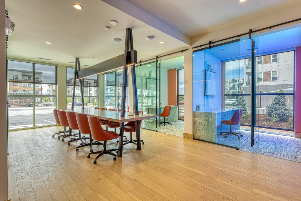 a conference room with a table and chairs in front of glass doors