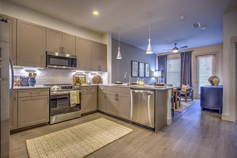 A kitchen with a refrigerator, oven, and microwave.