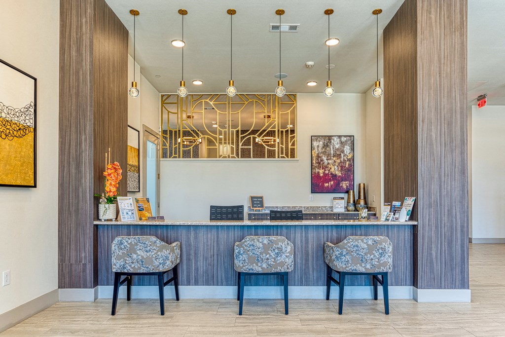 a reception desk with three chairs and a mirror on the wall