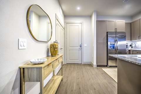 A modern kitchen with a wooden island and stainless steel appliances.