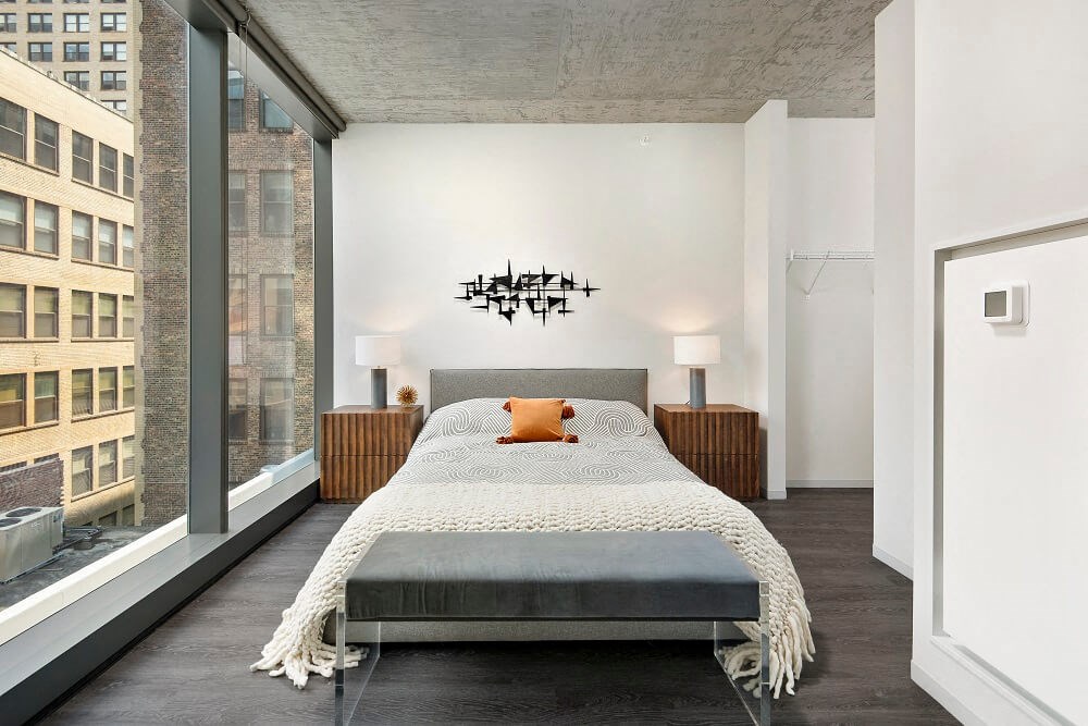 a bedroom with a bed and a large window