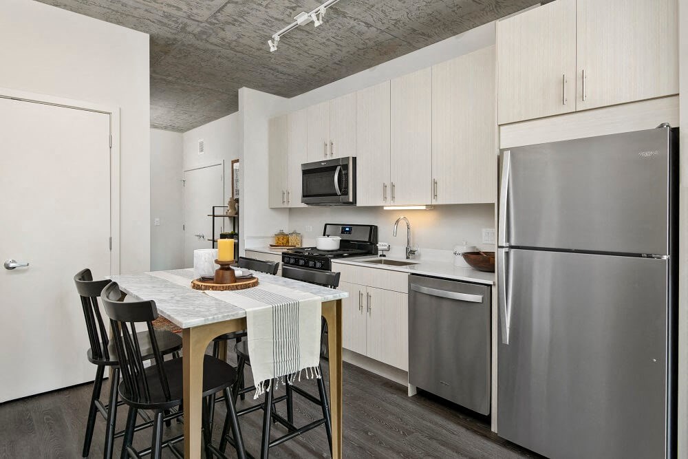 a kitchen with stainless steel appliances and a table with chairs