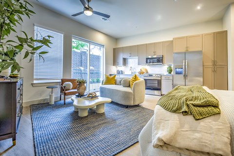 A well-lit, modern kitchen and living room with a dining table and chairs.