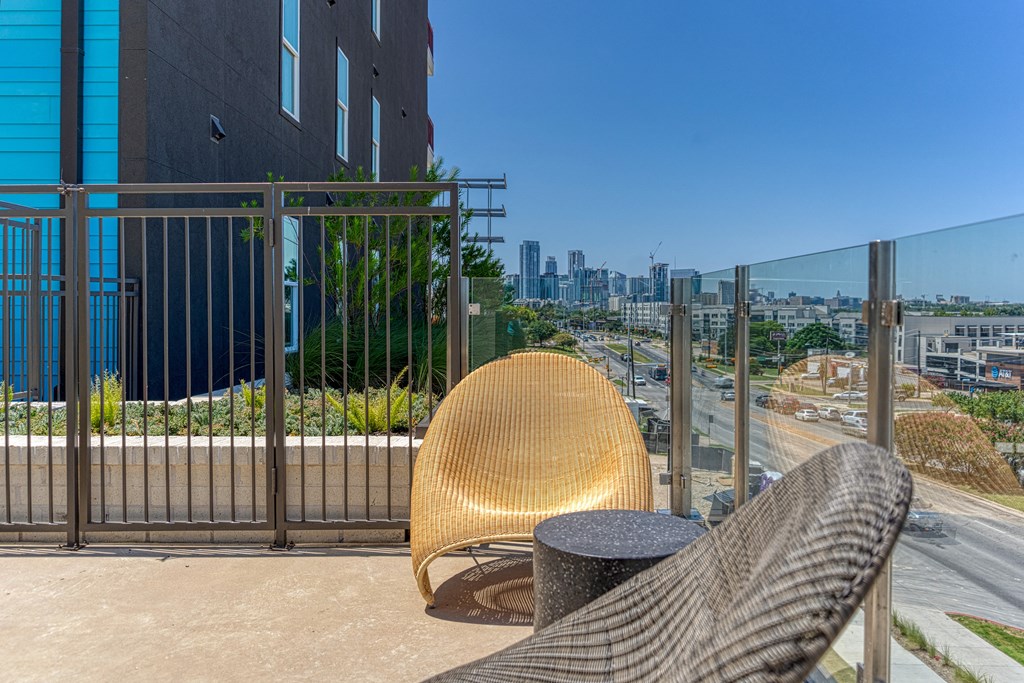 a chair and table on a balcony with a view of the city