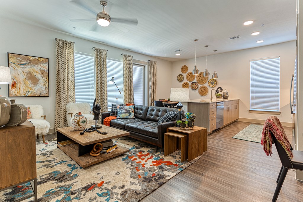 Apartment living room the opens into the kitchen with natural wood tones