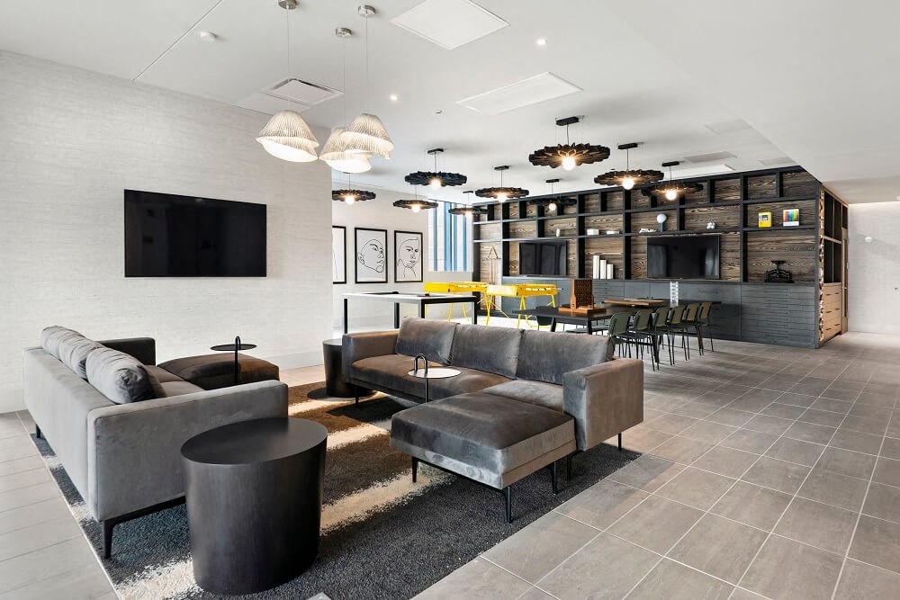 a lobby with couches chairs and a bar and a television