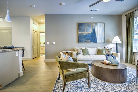 A living room with a green chair and a painting on the wall.