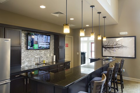 A modern kitchen with dark cabinets and a stainless steel refrigerator.
