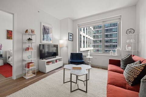 A living room with a red couch and a white coffee table.