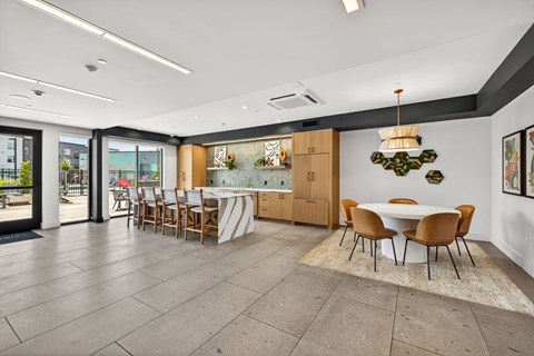 A dining room with a table surrounded by chairs.