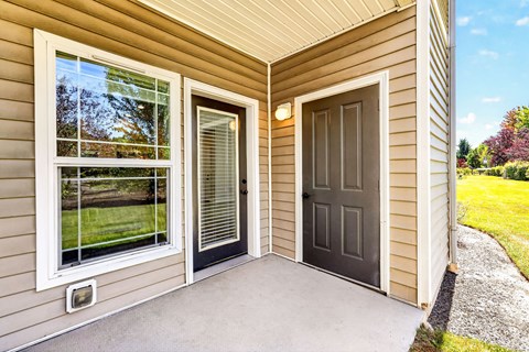 A house with a brown door and a window with blinds.