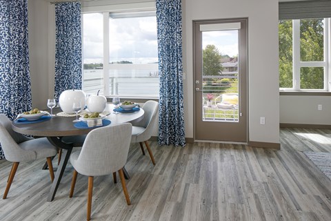 A dining room with a table and a view of the water.