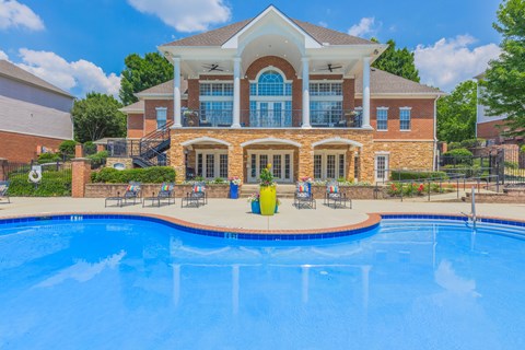 A large house with a pool in front.