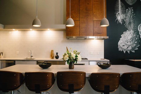 a kitchen with a long table and wooden chairs