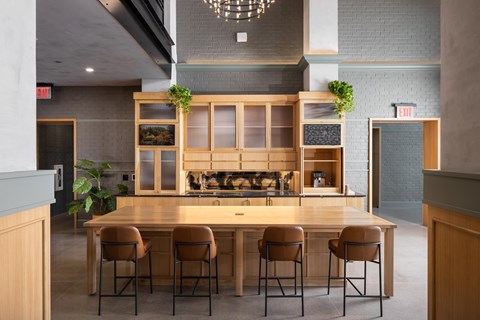 A modern kitchen with a long wooden table and chairs.