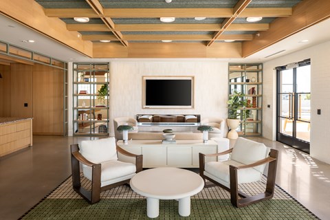 A modern living room with a white sofa set and a flat screen TV.