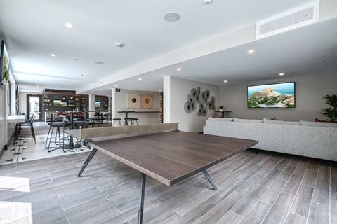 a communal table in a living room with a couch and a tv