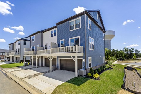 A blue two-story house with a garage and a driveway.