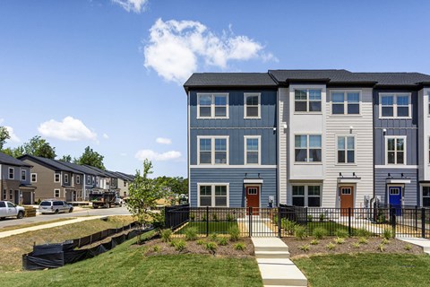 A row of townhouses with a clear blue sky above them.