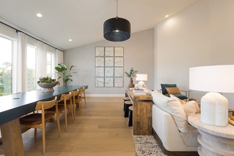 a living room and dining room with a long table and a couch