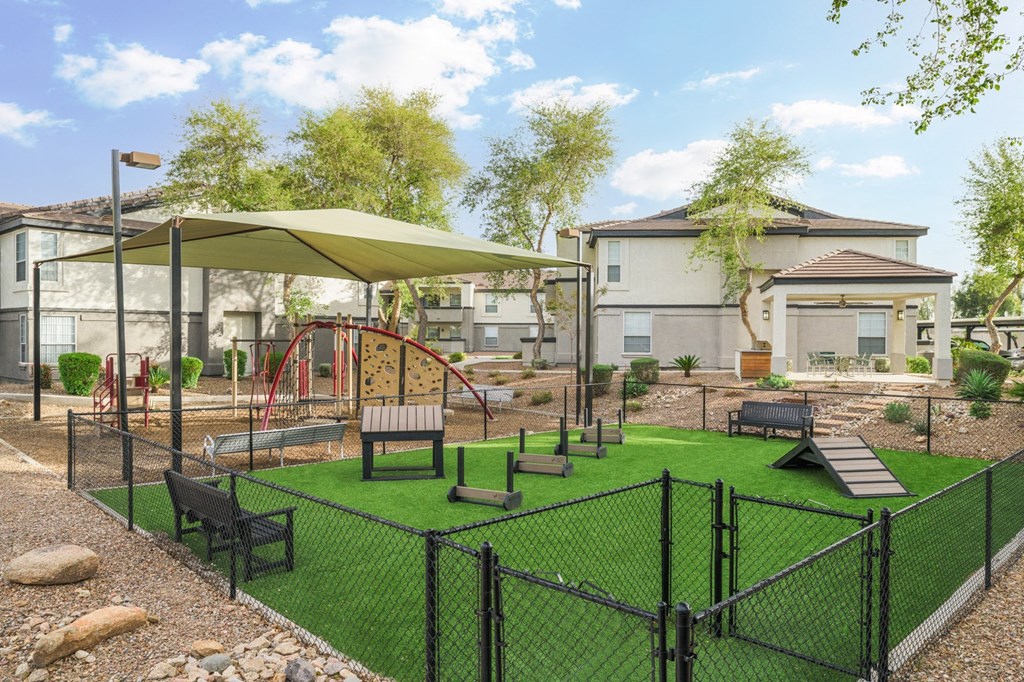 a fenced in play area with benches and umbrellas