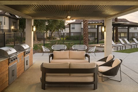 a patio with a couch and chairs and a grill